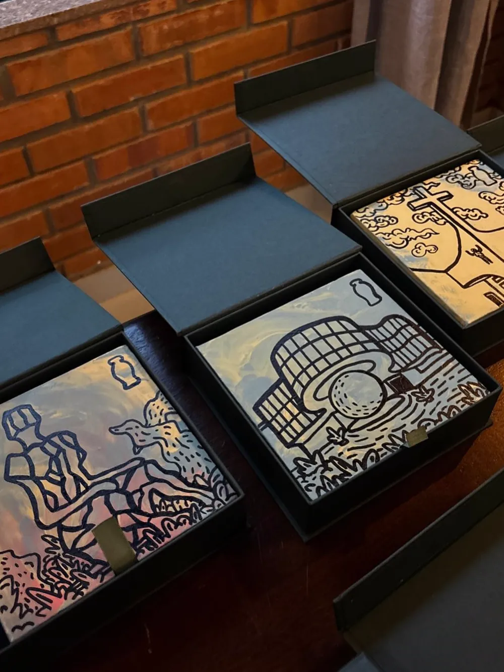 Caixas verdes abertas com azulejos pintados à mão
